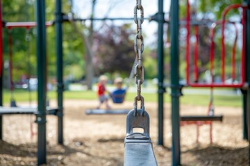 Children swinging on contemporary playground s chained swings