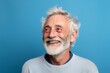 © Inigo - Portrait of happy senior man with white hair and beard on blue background