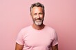© Inigo - Handsome mature man in pink t-shirt. Studio shot.