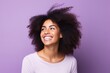 Portrait of a beautiful young african american woman smiling against purple background