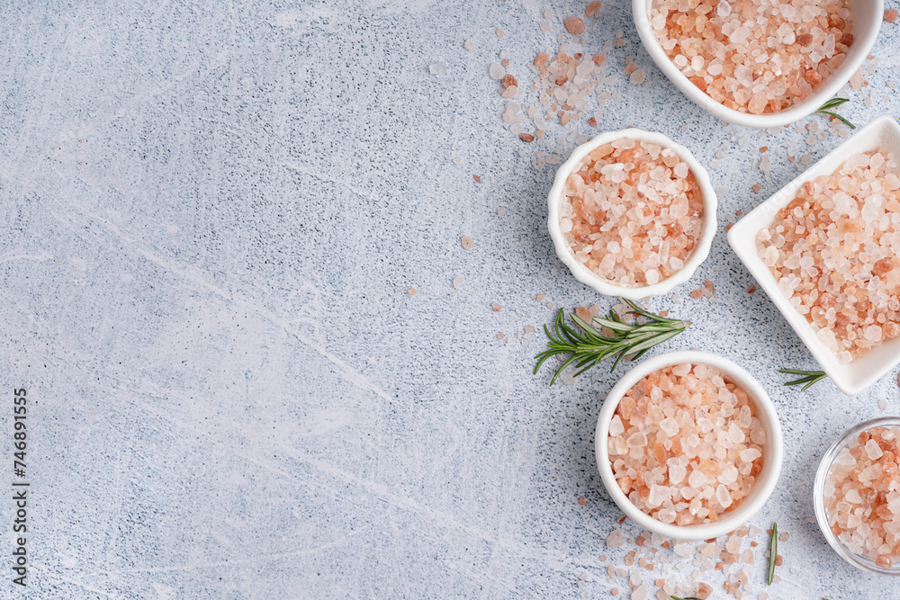Bowls with Himalayan pink salt and rosemary on white background