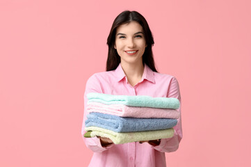 Sticker - Beautiful young woman with clean towels on pink background