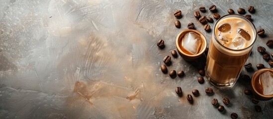 Poster - Two clear glass tumblers filled with iced coffee sit on a table, surrounded by a scattering of coffee beans. The refreshing drinks are perfect for a warm day.