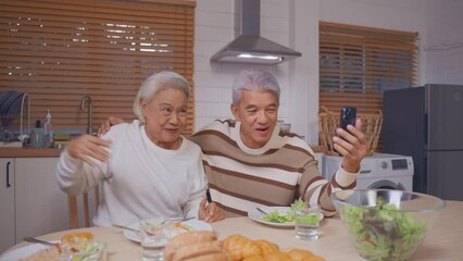 Wall Mural - Asian family doing video call while having dinner in house together. 