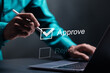 © Pakin - Option to approve or reject. Businessman tick a checkbox with the text approve. Deciding between approve or rejecting for business project.