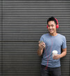 © Image Smith - Asian man casual dressed with headphones and smart phone.