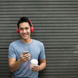© Image Smith - Asian man casual dressed with headphones and smart phone.