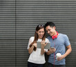 © Image Smith - Asian man and woman using digital tablet outdoors.