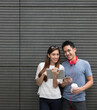 © Image Smith - Asian man and woman using digital tablet outdoors.