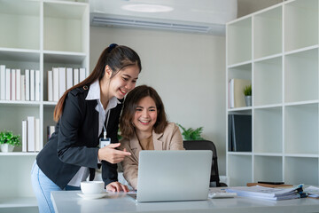 Canvas Print - Two businesswoman discussing partner discussing project on laptop in office. Two colleague of professional business people working together at workspace