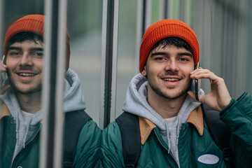 Wall Mural - young man on the street wrapped up talking on the mobile phone