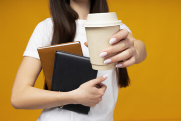 Wall Mural - Attractive young woman with coffee and books in hands