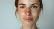 close-up captures the stark comparison between youthful and aged skin on a woman's face. The neutral background accentuates the focus on the woman's face, viewers to differences between the two sides.