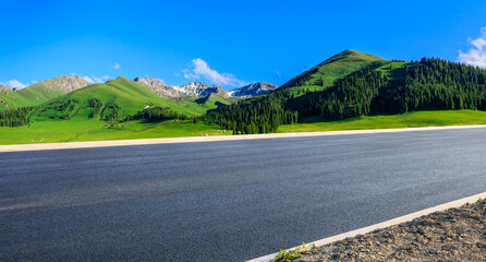 Wall Mural - Asphalt highway road and green forest with mountain nature landscape under blue sky