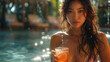 A sexy and beautiful Japanese woman in a glamorous wearing bikini and sipping a cocktail by a resort pool.