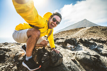 happy hiker having fun hiking mountains - active young man taking selfie pic with smart mobile phone