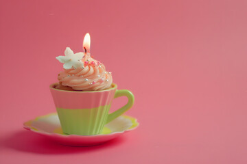 Poster - miniature cupcake in a pink cup with a candle set on the pink background