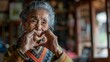 Portrait of a senior woman forming a heart with her hands, conveying love and emotion, perfect for projects on aging, love, and cultural diversity.
