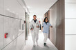 © Koldo_Studio - Two healthcare professionals, a doctor and a nurse, swiftly moving through the brightly lit corridor of an emergency unit