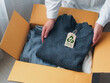 © pada smith - Sustainable product concept, Zero Waste, eco-friendly. An environmentally conscious entrepreneur packs clothes made from natural materials into cardboard boxes to ship to customers.