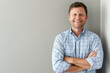 © Alienmonster Images - Confident Young Businessman in Casual Attire Leaning Against a Neutral Background with Ample Copy Space