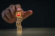 © PlengPleng - Hand Stacking Emotional Expression Blocks. A hand is stacking wooden blocks with various emotional faces, symbolizing the management of emotions. Symbol of customer satisfaction concept.