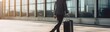 Businessman in suit walking with suitcase at airport terminal, panoramic banner. Travel and business concept . Travel concept. Travelling.