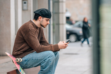 Poster - young man on the street with mobile phone and skateboard