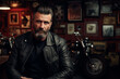 An adult man of about 45 years old dressed in a black leather jacket posing looking at the camera in a rock bar with a motorcycle