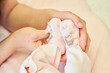 © Fotoproff - A woman's hand holds the baby's legs. A newborn baby.