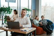 © standret - Sitting by laptops. People are working in the office with bean bags chairs in it