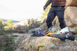 © ADDICTIVE STOCK - Close-up of essential climbing gear placed on a rocky surface with blurred anonymous climbers in the background, ready for a mountain adventure