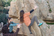 © ADDICTIVE STOCK - A climber reaches for a high hold, supported by attentive teammates, amidst a rugged granite boulder landscape