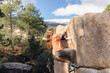 © ADDICTIVE STOCK - A lone climber skillfully ascends a tall boulder, with a stunning snow-capped mountain range in the distance
