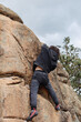 © ADDICTIVE STOCK - Focused and determined, a climber makes upward progress on a textured granite boulder, showcasing their climbing technique