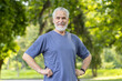 © Liubomir - Smiling senior man standing confidently in park with hands on hips