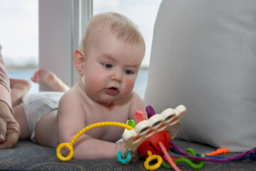 Four month old baby boy playing with toy.