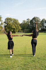 Wall Mural - Young female friends walking in park after exercising