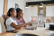 © Cultura Creative - Serious lesbian couple using laptop at home