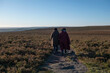 © Cultura Creative - Rear view of two women hiking in moorland