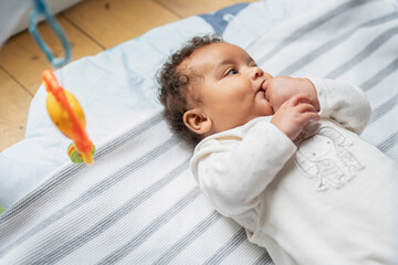 Canvas Print - Baby girl lying on play mat at home