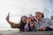Grandmother, mother and daughter taking selfie with smart phone