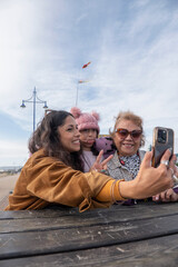 Poster - Grandmother, mother and daughter taking selfie with smart phone
