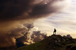 Ein Mann steht auf einem Berg und schaut in eine fantastische Wolkenlandschaft
