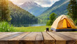 Wooden table in the blur camping tent at sunset in the mountain near the lake. Cool and relaxing concept. For product display montage or key visual layout design. space for text