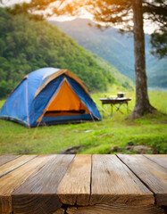 wooden table in blur camping tent and grass field. cool and relaxing concept. for product display mo