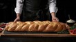Chef's hands with freshly baked fragrant bread with a crispy crust.