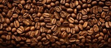 A Large Quantity Of Coffee Beans Spread Out Across A Wooden Table, Creating A Rich And Aromatic Display. The Beans Are Various Shades Of Brown And Have A Glossy Sheen, Enhancing Their Appeal.