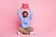 Full length photo of handsome young male sit floor raise popcorn look up dressed stylish blue garment isolated on pink color background