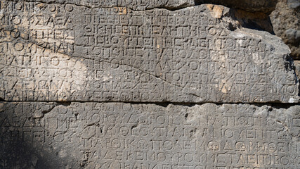 Wall Mural - Close-up  background of ancient Greek writings on the ruins of an ancient city